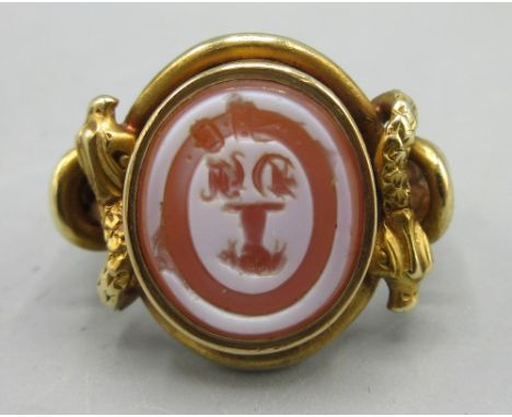 Late Georgian unmarked yellow metal intaglio ring, set with carnelian with unknown engraved coat of arms, possibly depicting 