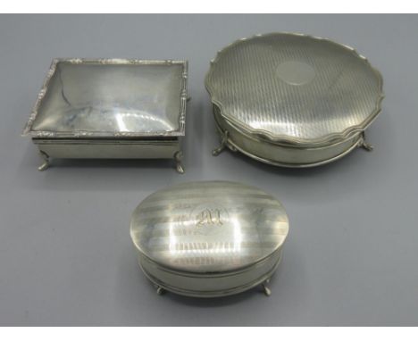George V silver trinket box with engine turned stripes, circular cartouche, gilt interior with blue satin cushion, weighted b
