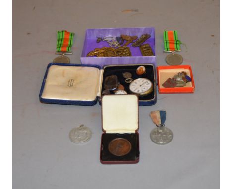A parcel lot containing WW1 cap badges, WW2 medals, enamel badges, silver, pocket watches etc