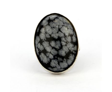 A 925 silver ring set with a large oval cabochon snowflake obsidian, (O.5).