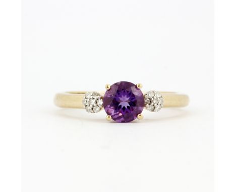 A hallmarked 9ct yellow gold ring set with a round cut amethyst and diamond set shoulders, (O.5).