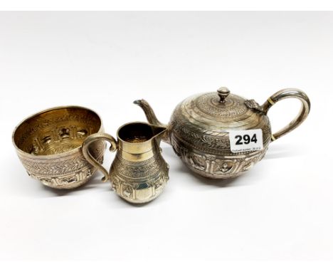 A Victorian British hallmarked Indian hammered silver tea set, teapot L. 20cm.