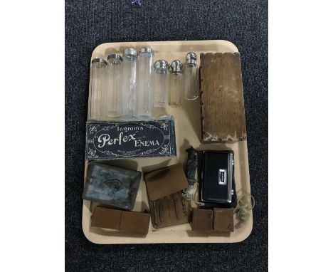 A tray containing seven glass bottles, two with silver tops, leather cased tools, a miniature oak trinket box in the form of 