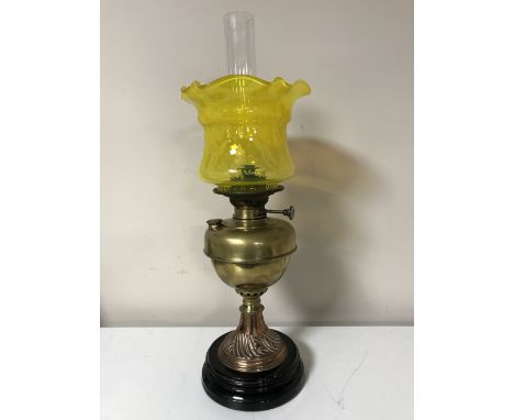 An early twentieth century brass National Lamp oil lamp with yellow glass shade and chimney 