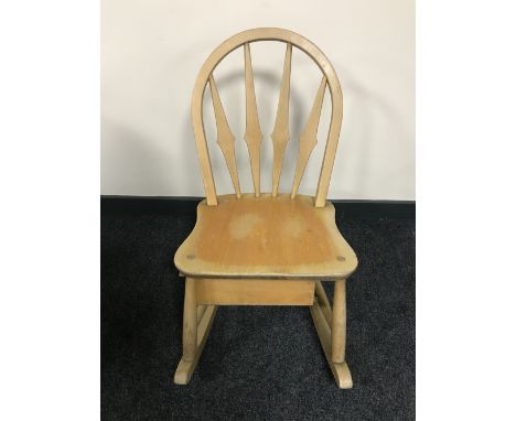 A children's Ercol rocking chair, fitted with a storage box beneath, together with a brass embossed fire screen  