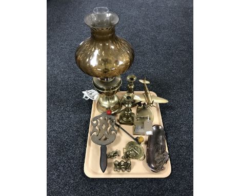 A tray containing a pair of brass candlesticks, a brass mantel clock, a brass model of a Spitfire, converted oil lamp etc