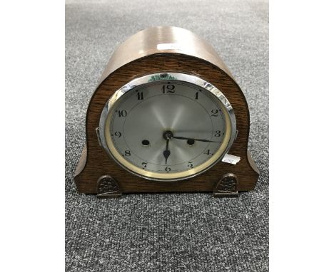 An oak cased mantel clock with silvered dial (with pendulum and key)