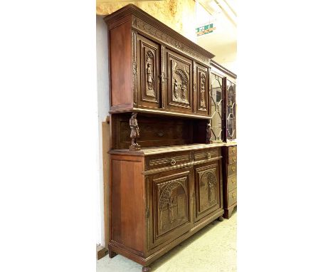 BUFFET A DEUX CORPS, early 20th century Continental oak, with five carved panel doors depicting figures in the Dutch manner a