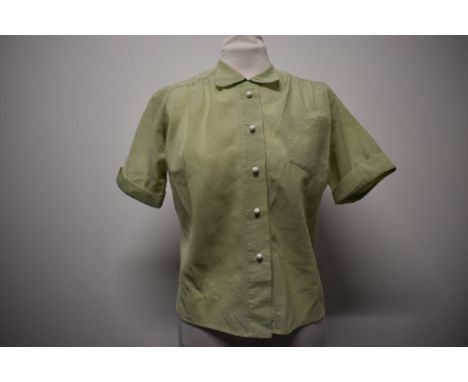 A 1950s mint green striped blouse, having 3/4 sleeves and spherical white buttons.