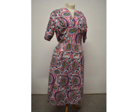 A vibrant 1950s cotton day dress, having V neckline, three quarter sleeves, side metal zip and patch pockets to skirt, medium