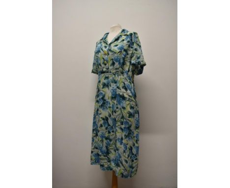 A vibrant 1950s day dress in a floppy rayon type fabric having bright absract floral print, larger size.