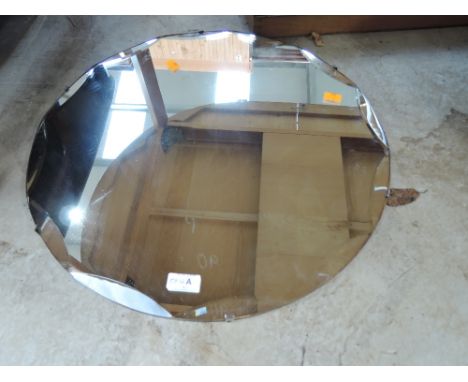 A vintage frameless circular mirror with bevelled edge