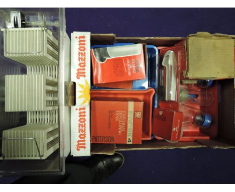 A box of development equipment including trays, measures, development tanks, film washer, light, viewer, tonges and drying ra