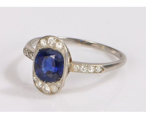 Art Deco sapphire and diamond set ring, the central oval sapphire with a diamond surround, further diamonds to the shoulders,