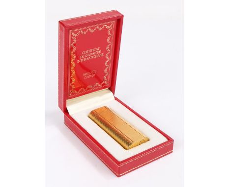 Cartier gold plated cigarette lighter, with engine turned banded exterior, 7.5cm high, housed in a Cartier box with guarantee