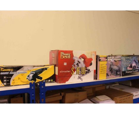 Four boxed power tools, angle grinder, circular saw, planer and bench grinder.