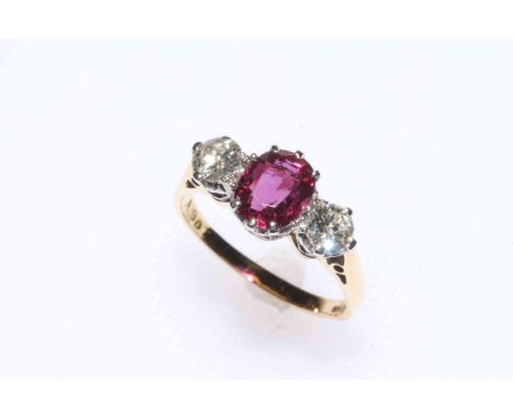 18 carat gold three stone ruby and diamond ring, the ruby approximately 0.75 carat flanked by brilliants, size I/J.