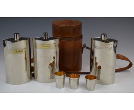 Circular leather spirit flask container with three sectional spirit flasks and four tot cups, height 18cm