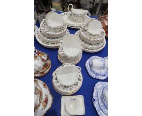 A Wedgwood Strawberry Hill pattern dinner service comprising two oval platters, sauce boat and two stands, eleven soup coupes