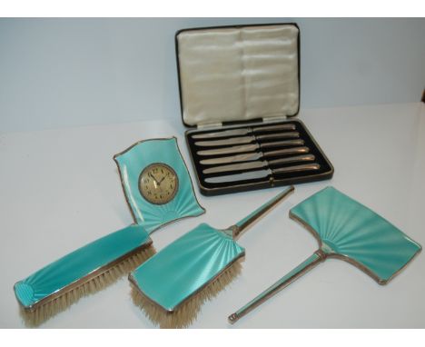 A silver-mounted and enamel brush set, enamel clock with easel stand and cased silver-handled knives Condition Report: Availa