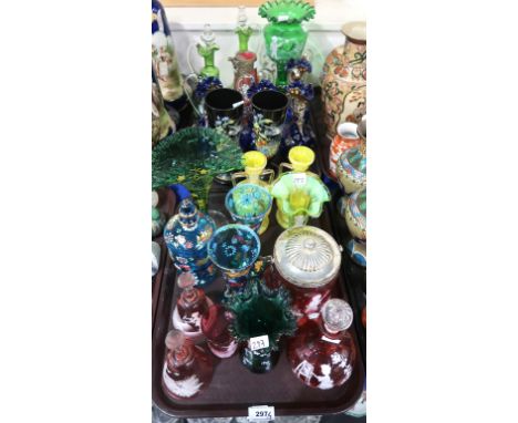 A selection of coloured glass including cranberry Mary Gregory style decanters, bells, biscuit barrel, other green glass ewer