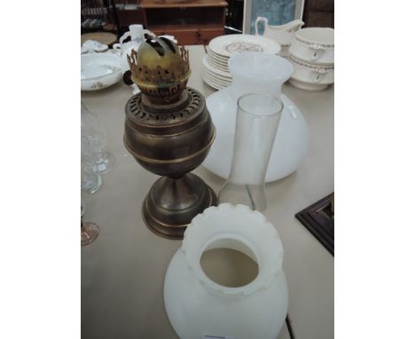 A brass paraffin lamp and shades