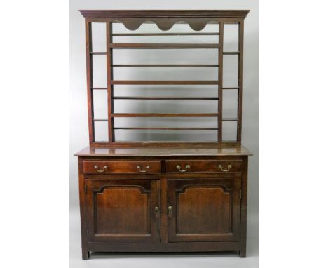 A George III oak dresser of panelled construction, the moulded rectangular top above two frieze drawers, cupboard below with 