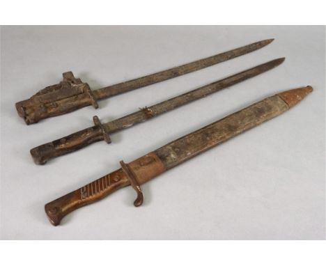 A collection of three bayonets, one in leather scabbard.