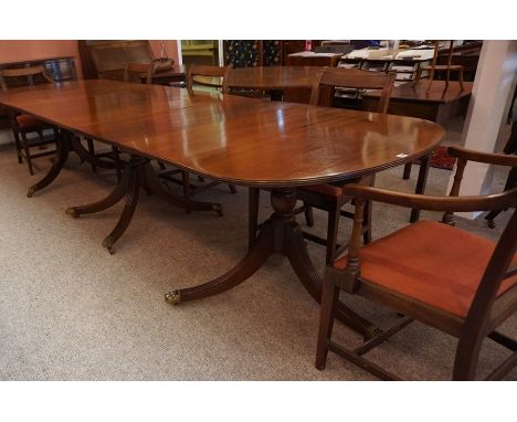 A Regency Style Mahogany Triple Pillar Dining Table, Having three additional leaves, raised on reeded tripod legs with brass 