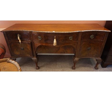 A Chippendale Style Mahogany Serpentine Sideboard, circa early 20th century, Having a large drawer above a deep drawer, flank