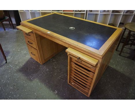 A Vintage Golden Oak Desk, Having two slides to the top, above three garduated drawers, flanked with a pull up door, enclosin