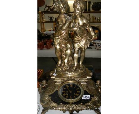 A mantel clock surmounted figures of a boy and girl
