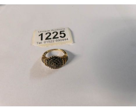 A yellow metal ring set black stones, size N