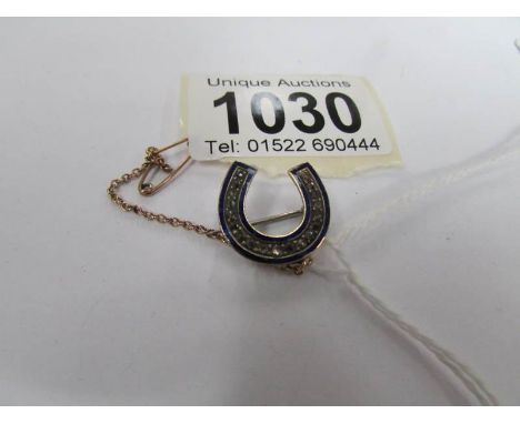 A yellow metal and enamel brooch set diamond chips and with safety chain