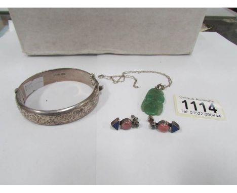 A silver bangle, a jade pendant on silver chain and a pair of possibly silver earrings