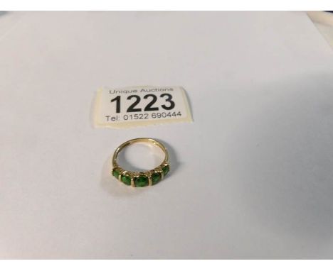 A 9ct gold ring set green stones, size N