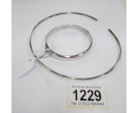 A silver neck collar and a silver bangle with safety chain