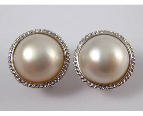 A pair of white metal (tests 14 carat gold) mabe pearl earrings, approx 17mm wide, 6.3 gms.
