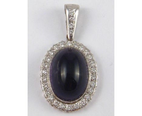 A white metal (tests 18 carat gold) amethyst and diamond pendant, the cabochon amethyst measuring approx 26 x 17.5mm, estimat