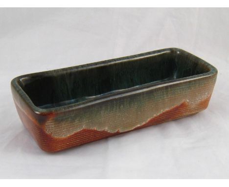 A ceramic rectangular dish, the inside mottled green, the outside striated, incised signature on the underside” E. Deutch 194