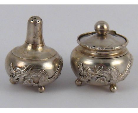 A Chinese silver pepper and mustard on three ball feet and with circling dragon. Chinese marks and "Silver". 