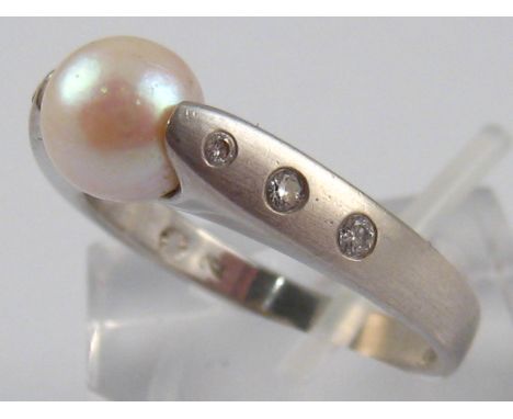 A white metal (tests 18 carat gold) cultured pearl and diamond ring, pearl approx 7.2mm diameter, ring size R, 6.4 gms.
