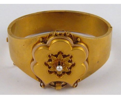 A Victorian 15 carat gold bangle, set with a seed pearl, bangle approx 3.5cm at widest, internal width approx 6cm, 29.9 gms.

