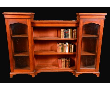 A Victorian mahogany low bookcase, moulded top with sunken centre above open shelves, flanked by a pair of glazed doors, skir