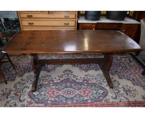 An Ercol elm trestle-type dining table, rounded rectangular top, vasular end supports, 183.5cm long