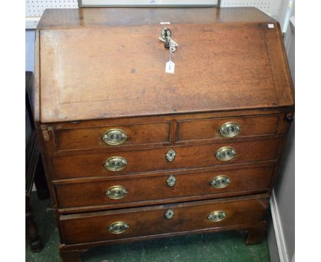 A George III oak bureau, fall front enclosing a cupboard and an arrangement of small drawers and pigeon holes, above two shor