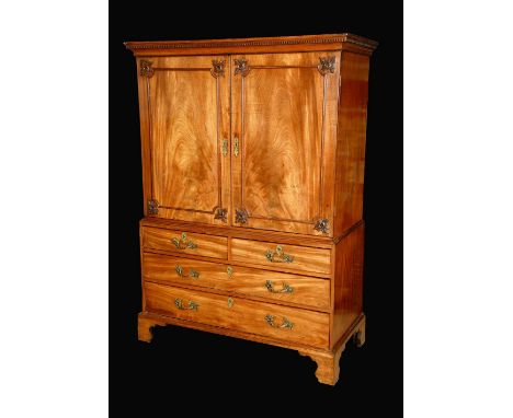 A 19th century mahogany linen press, dentil cornice above a pair of rectangular doors applied with re-entrant mouldings, the 