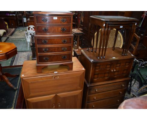 An Ercol style light elm bureau, fall front enclosing a partially segmented interior above a pair of cupboard doors enclosing