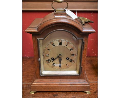 An oak bracket clock, silvered dial, Roman and Arabic numerals, 35cm high over handle