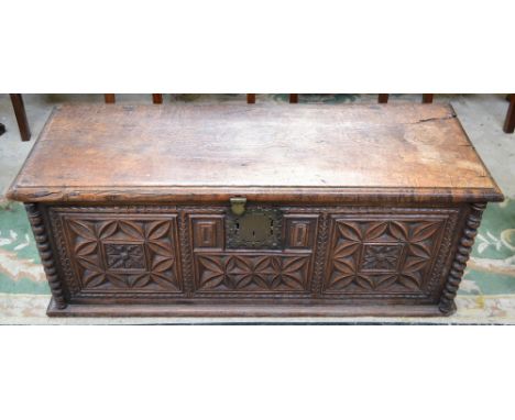 A 17th century South European chestnut chest, hinged rectangular top, the front panel carved with stylised flowerheads and ge